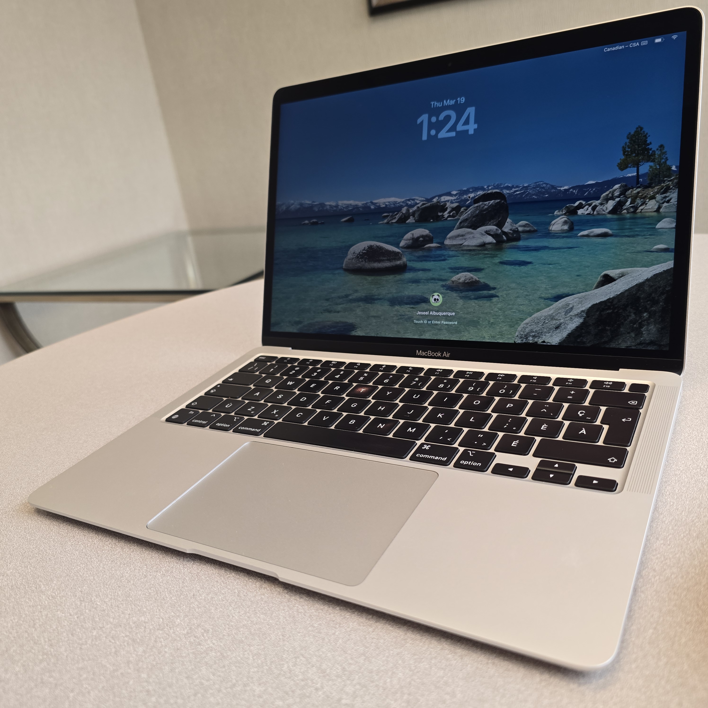 MacBook Air M1 2020 argent ouvert en angle, avec son écran, son clavier et son boîtier visibles